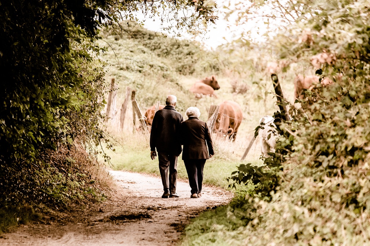 An older couple walking a country path, the long view that retirement planning protects.